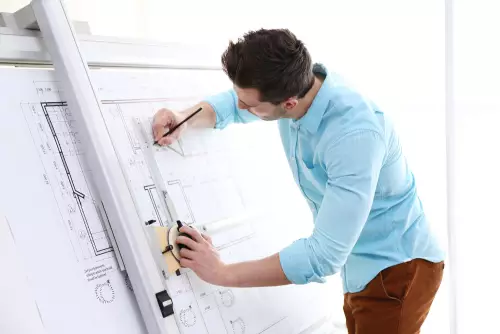 Un homme dessine sur un plan Un homme dessine sur un plan