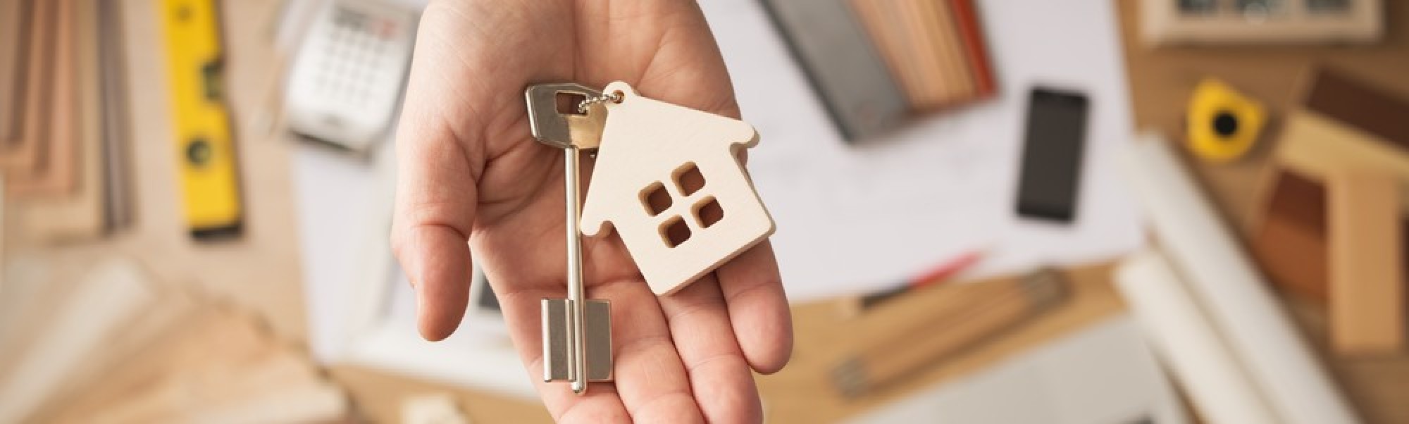 Des clés dans une main avec un porte-clés en forme de maison