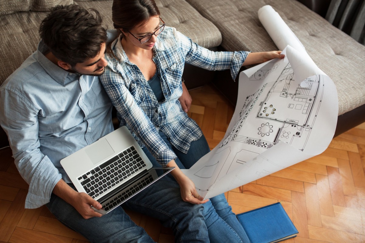 Un jeune couple examine les plans de son futur logement