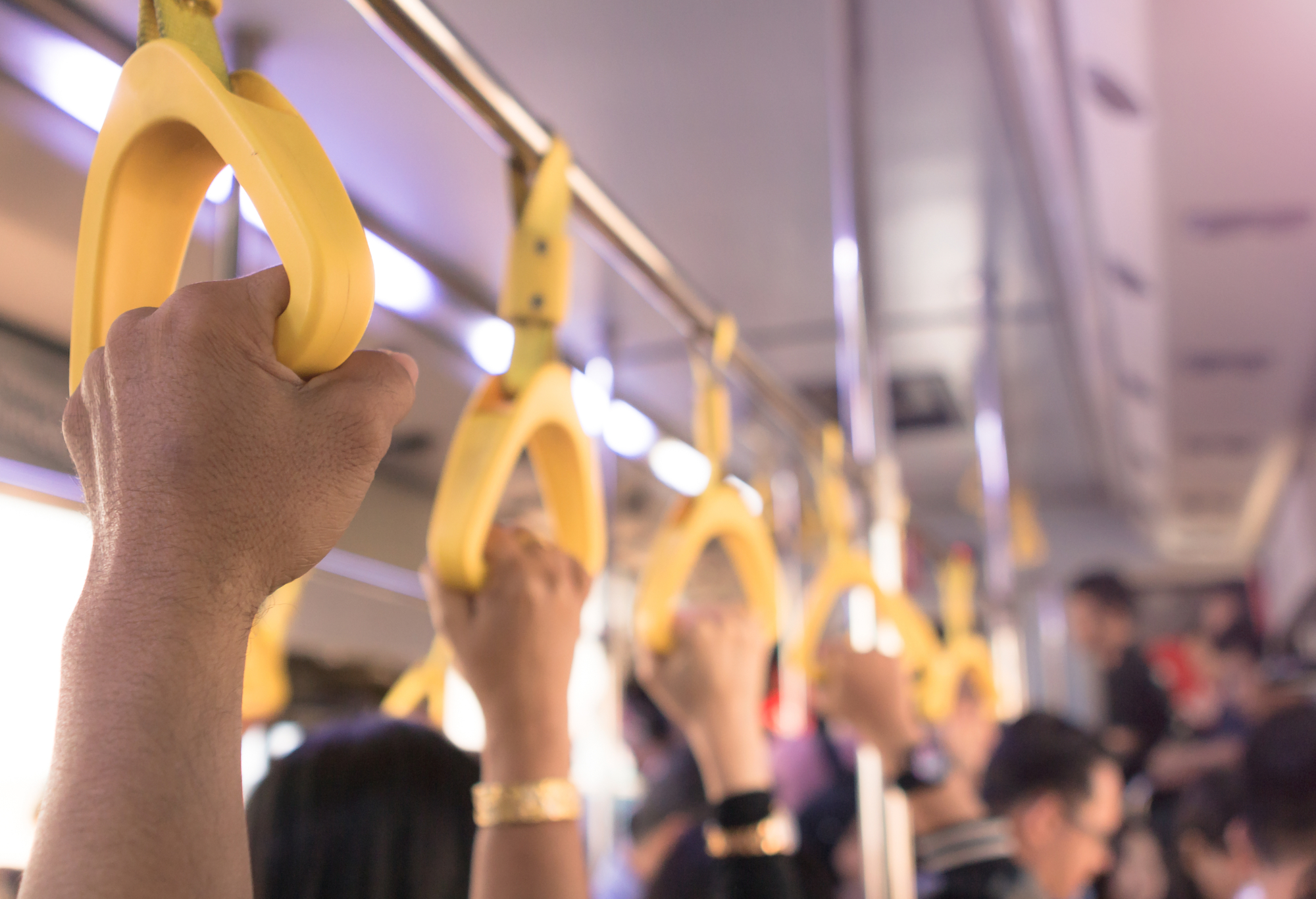 Nouvelle ligne de métro à Rennes - Mains qui tiennent des poignées dans un transport en commun.