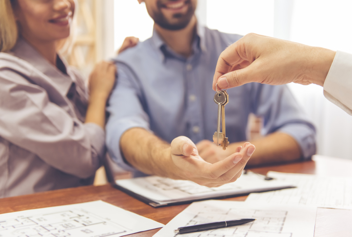 Achat immobilier neuf Rennes – l’agent immobilier remet les clés d’un logement à jeune couple de primo-accédants