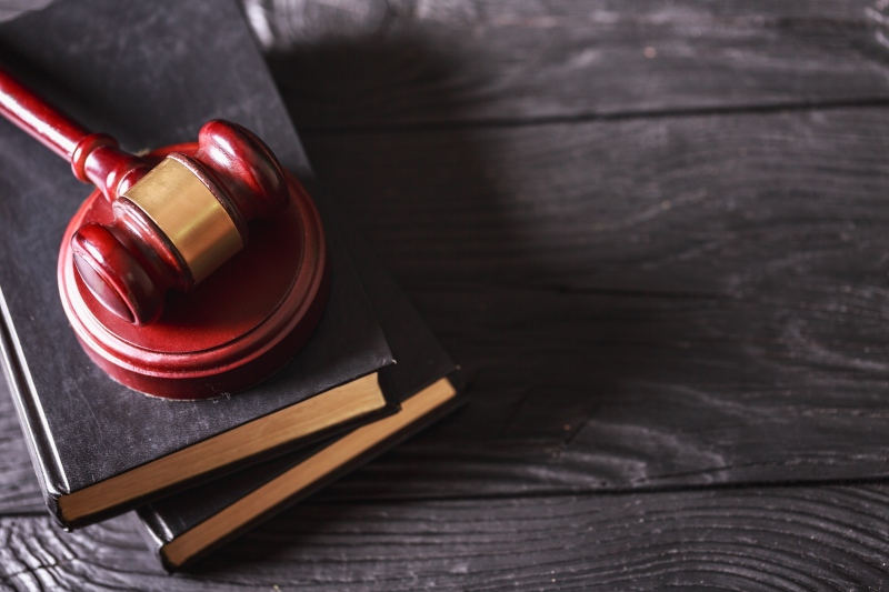 Loi 4D – Marteau de juge posé sur des livres de droit