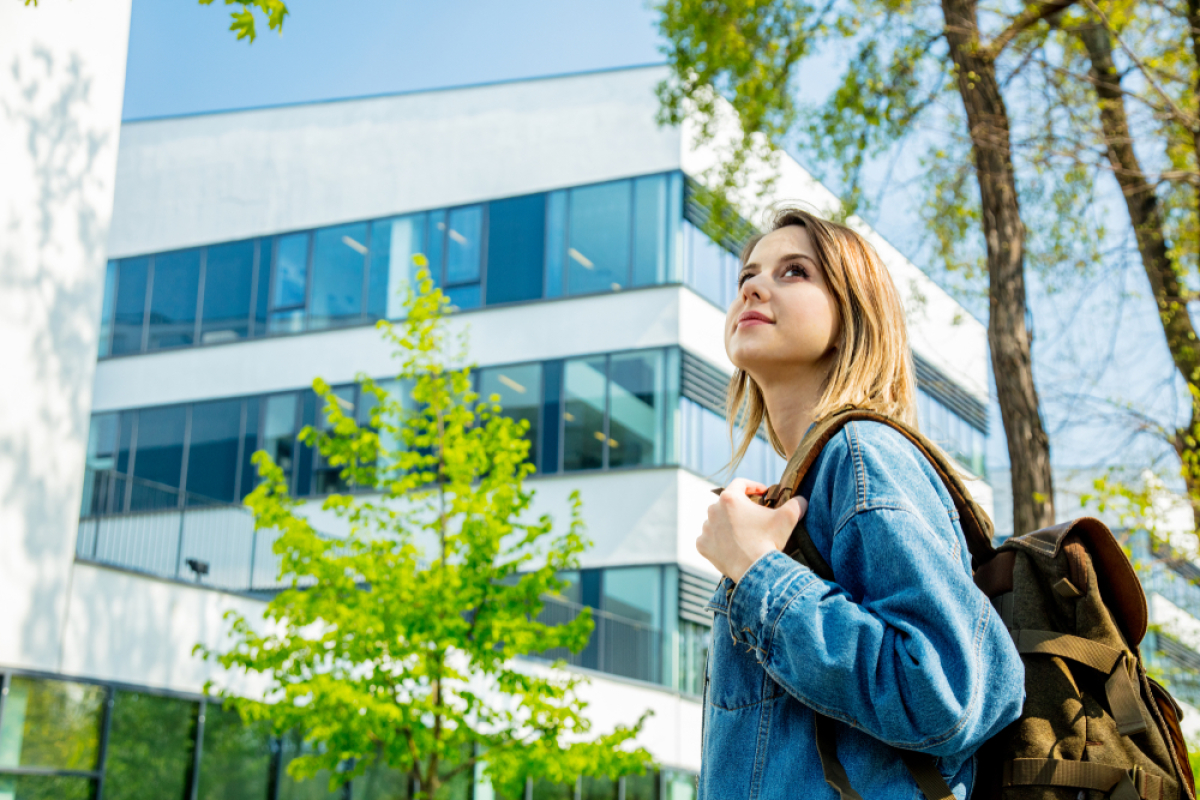 Appartement neuf Rennes – une jeune étudiante se trouve devant un bâtiment universitaire