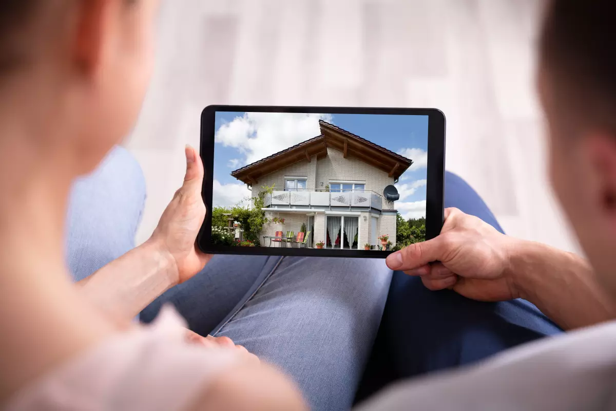 Couple regardant une maison sur tablette
