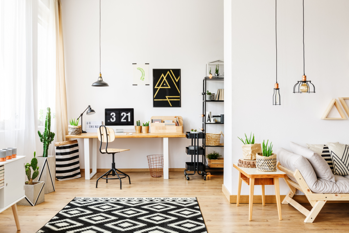 Vue de l'intérieur de la pièce de vie d’un appartement meublé avec un bureau et un canapé