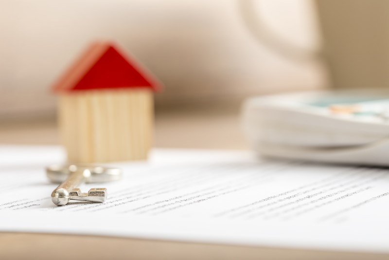 Comment choisir son locataire – Une maison miniature et une clé sur un document