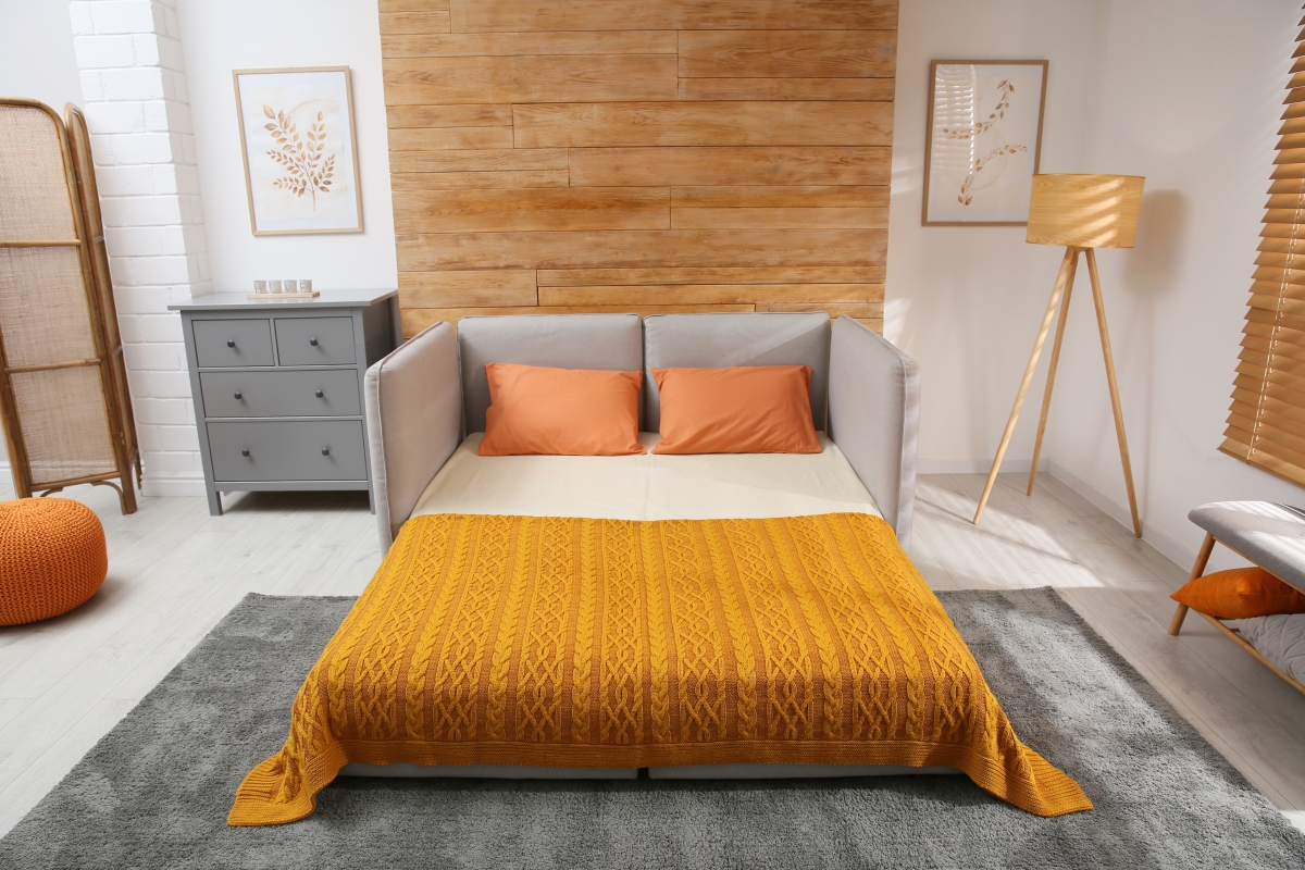 le clic clac et le BZ sont des meubles indispensables dans un studio bas de plafond. un couchage clic clac déplié dans un studio décoré ambiance nature