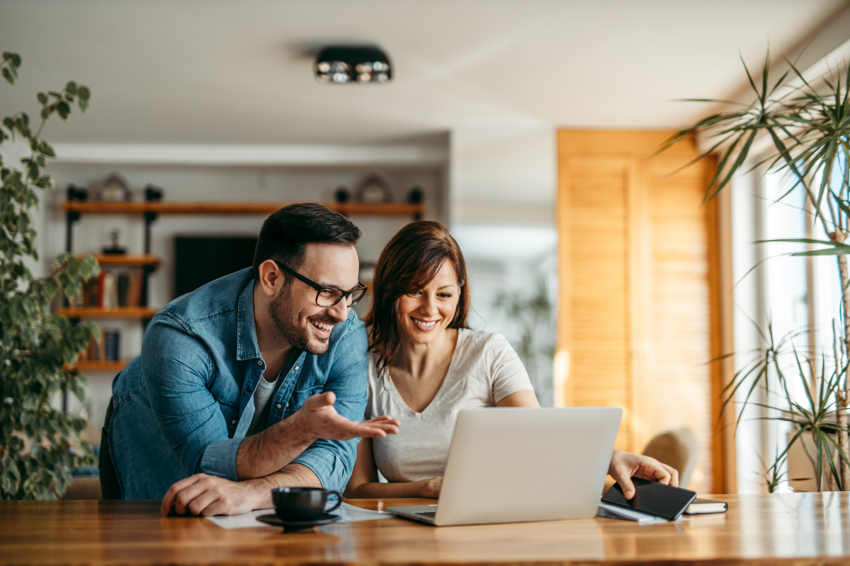 comment remplir déclaration impôt pinel – un couple souriant devant un ordinateur portable ouvert