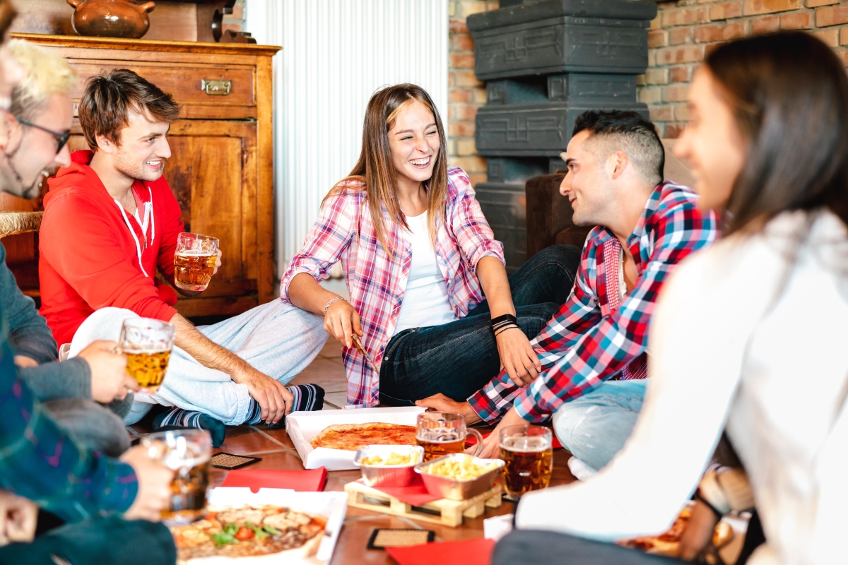 des colocataires riant autour d’une pizza