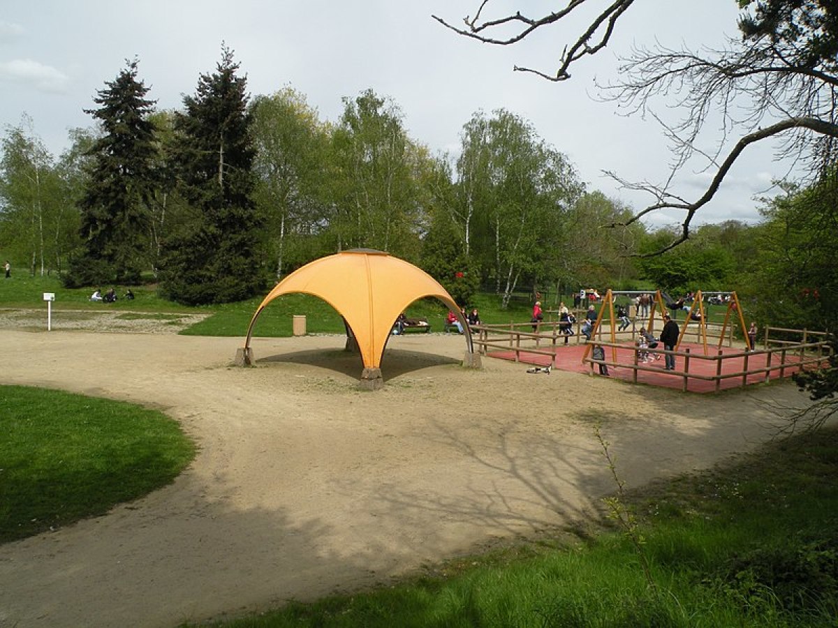 le parc de bréquigny avec des jeux pour enfants et un pare soleil jaune
