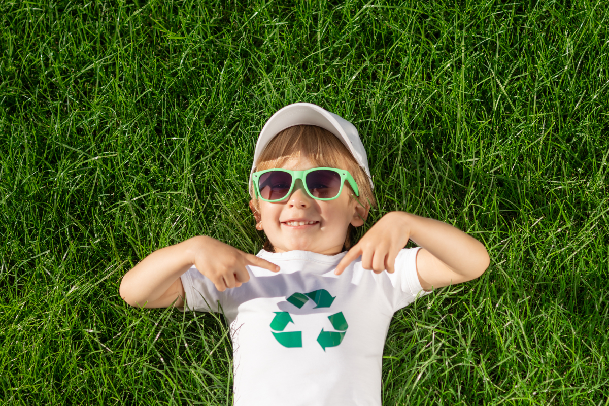 renouvellement urbain le rheu – un enfant avec un tshirt recyclage allongé dans l’herbe