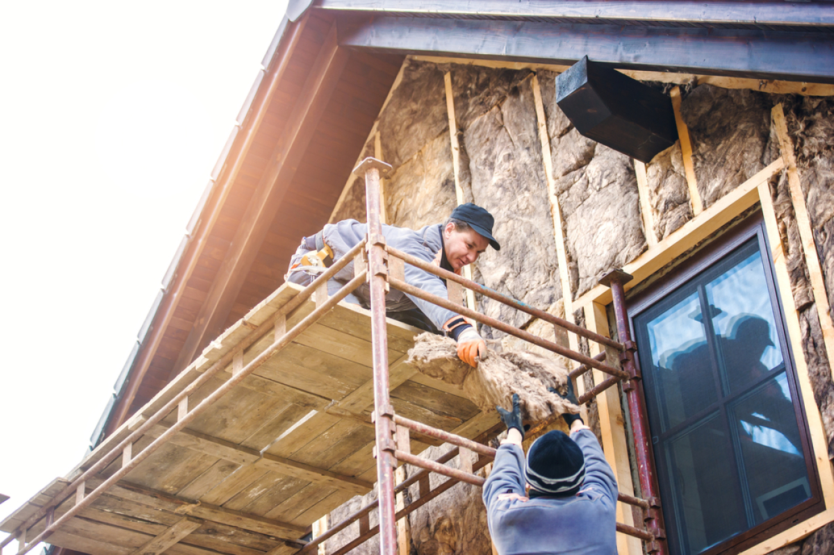 isolation thermique logement neuf – deux professionnels du bâtiment isolent la façade d’une maison avec de la laine de verre