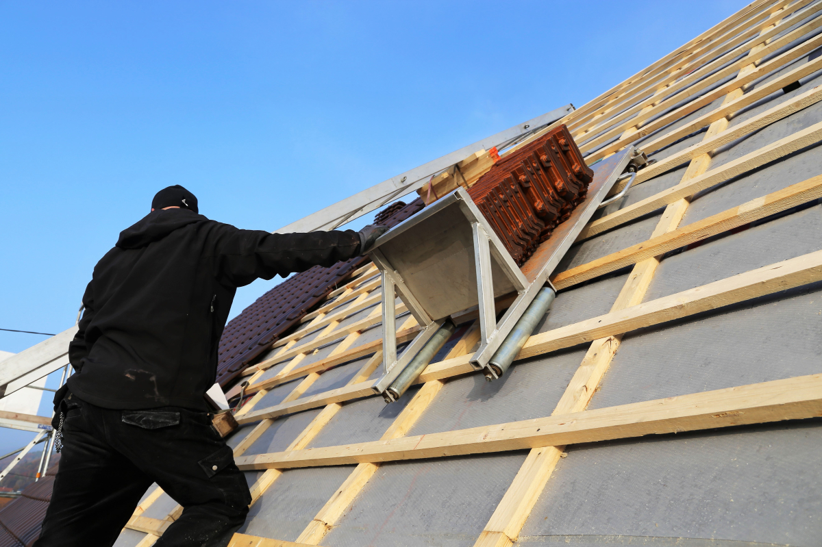 un ouvrier du bâtiment travaille sur une toiture