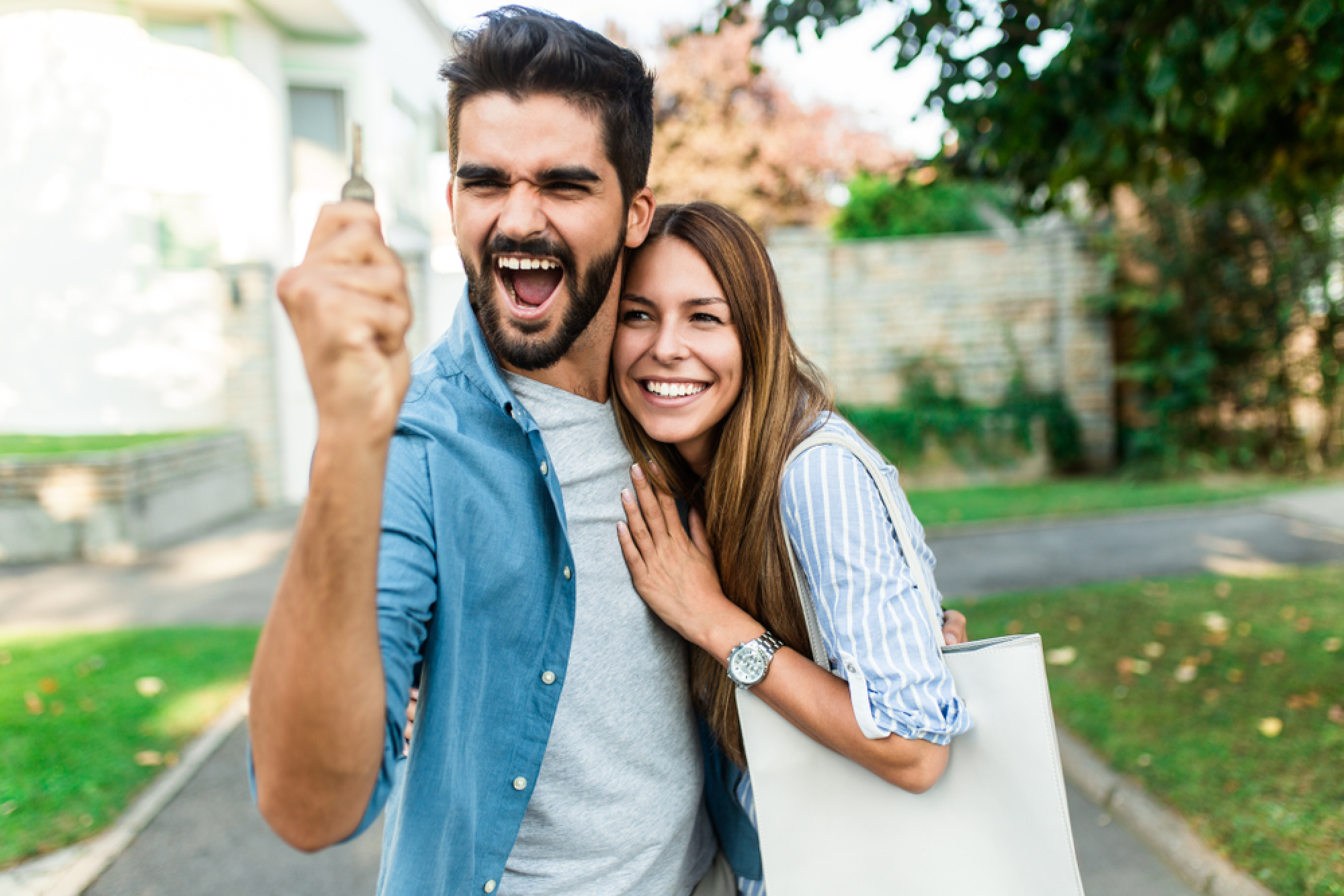 un couple avec un homme heureux tenant une clé dans sa main