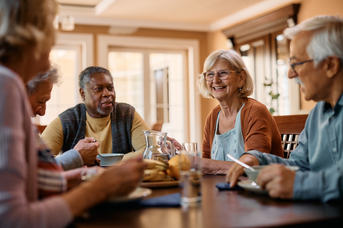 un groupe de jeunes seniors riant à table