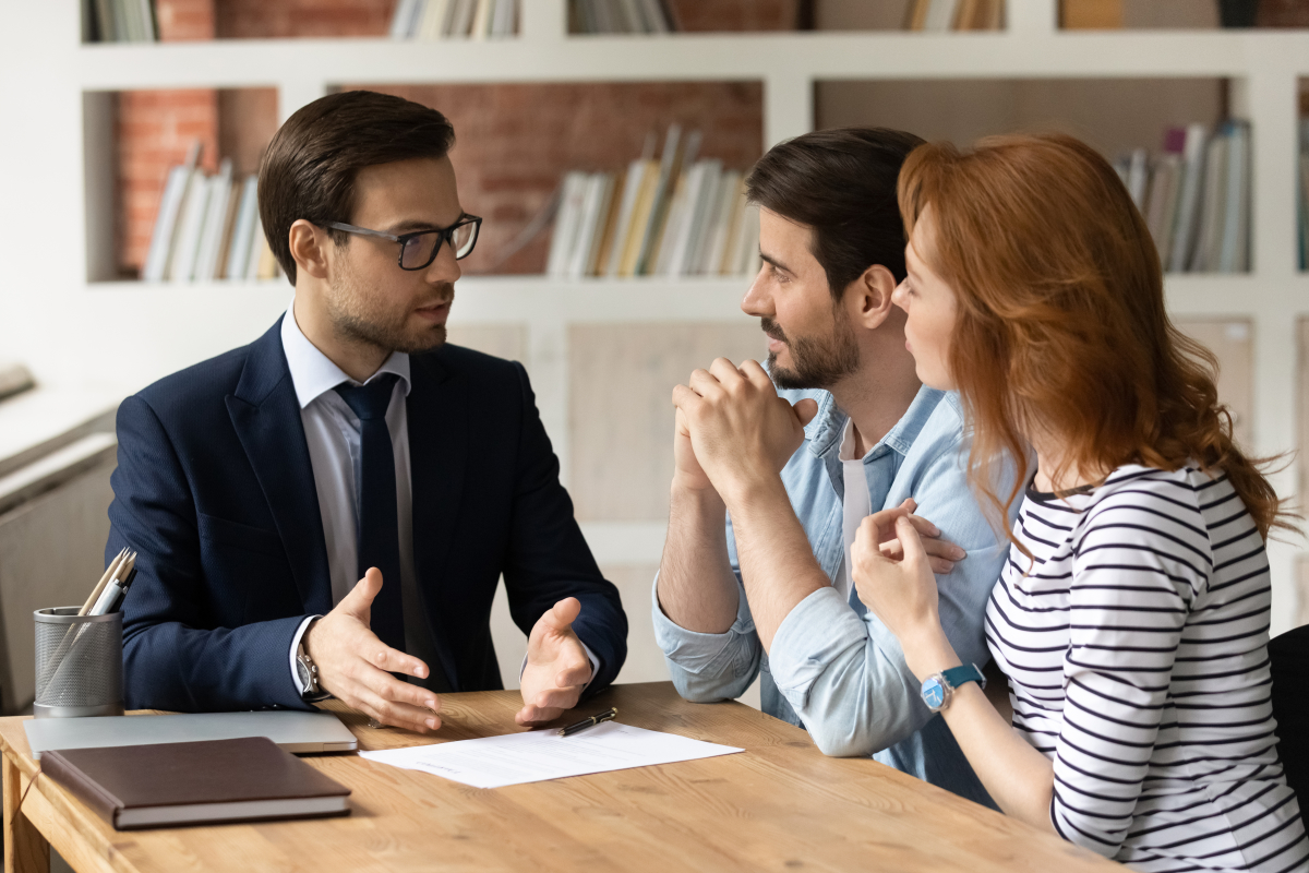 un couple dans un bureau avec un conseiller en immobilier neuf