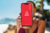 Une jeune femme tend un téléphone avec le logo airbnb dessus