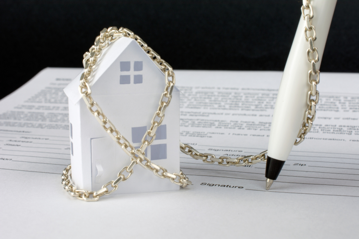comment expulser un locataire – un stylo enchaîné à une maison signe un contrat