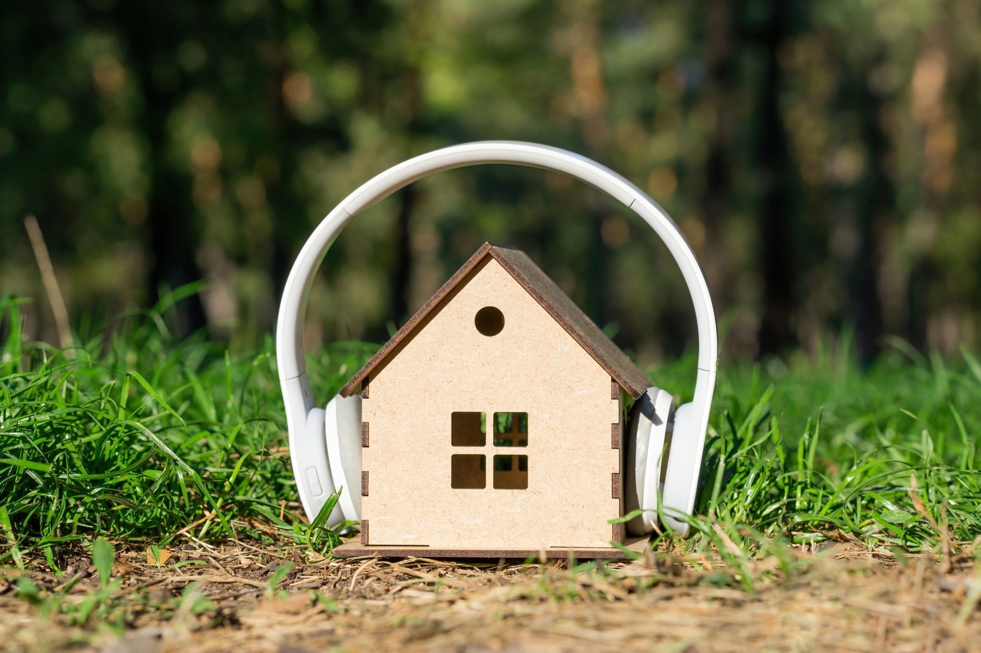 une maquette de maison en bois portant un casque anti-bruit