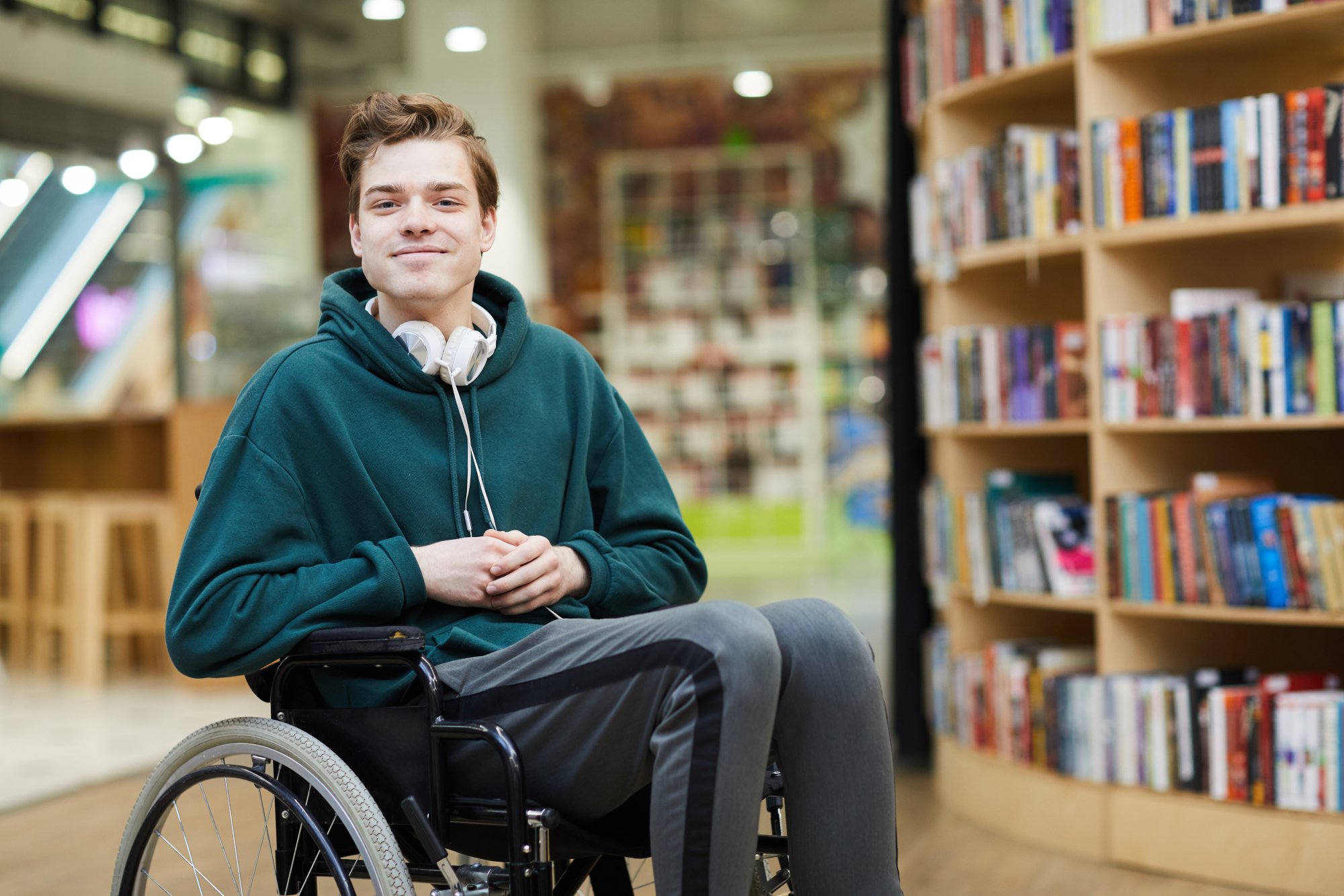 Un jeune homme en situation de handicap dans son fauteuil roulant