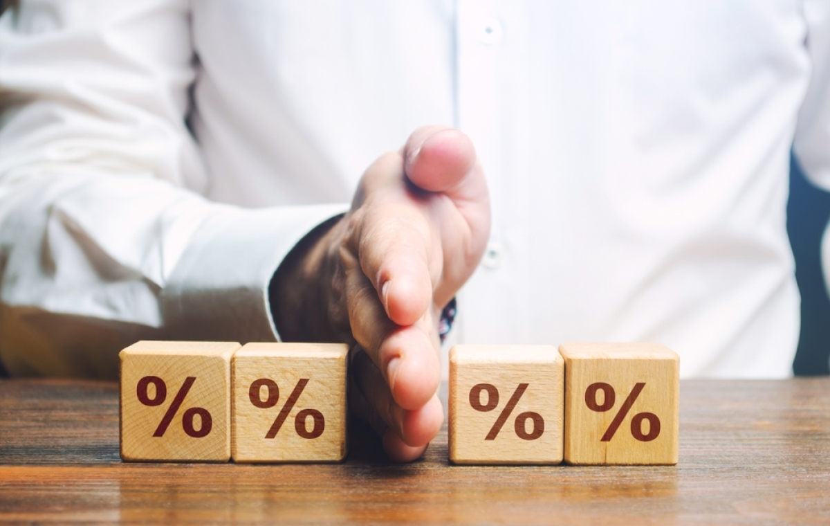 intérêts d'emprunt déductibles 2025 – un homme sépare des cubes de pourcentages pour symboliser une réduction de taxe