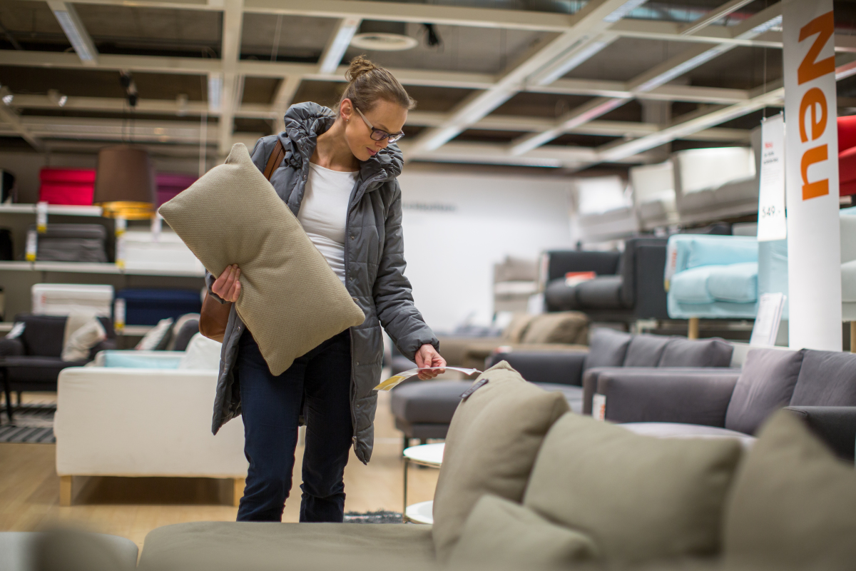 femme examinant un canapé dans un magasin de meubles