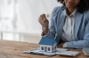 une femme tient une clé au-dessus d'une maquette de maison