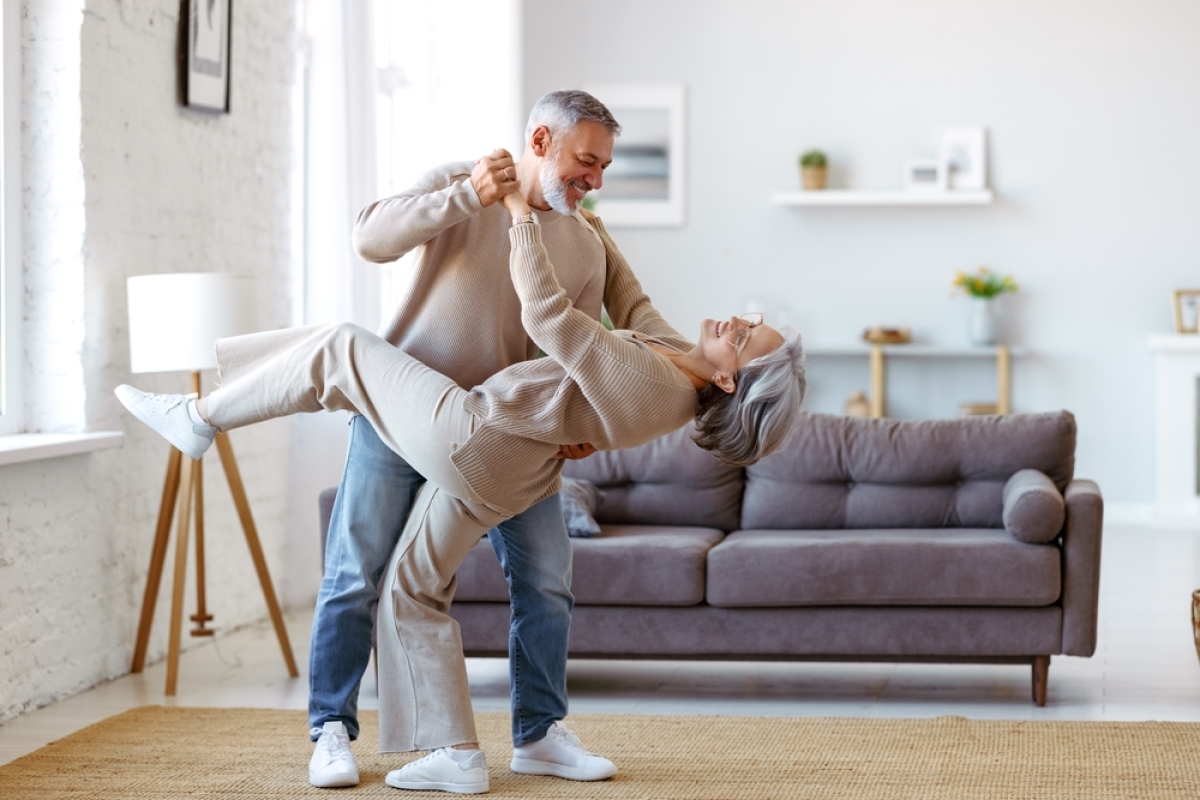 tva et lmnp – un couple de seniors dansent dans leur salon