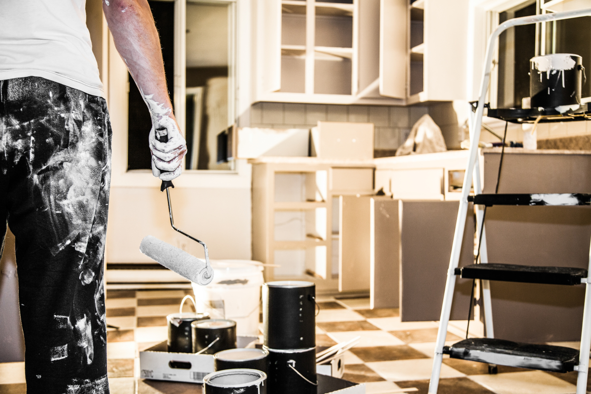 cuisine en travaux avec silhouette de femme tachée et équipée d’un rouleau à peinture