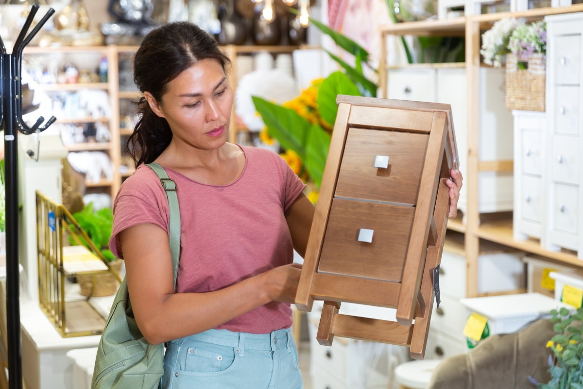 une femme achète un petit meuble de type chevet