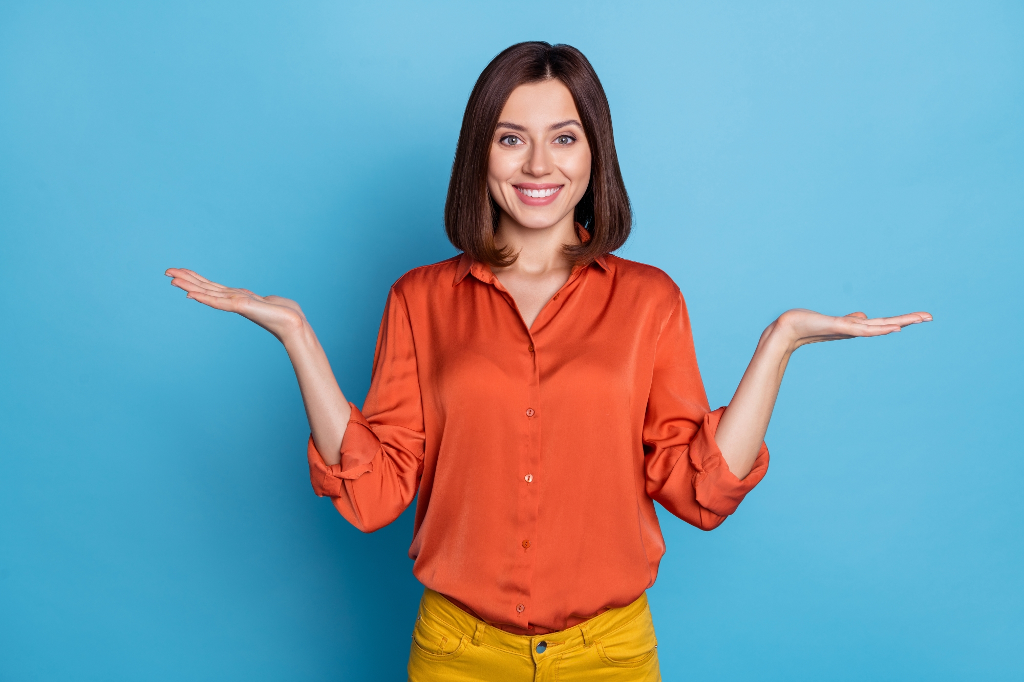 femme en chemise orange sur fond bleu qui se pose des questions