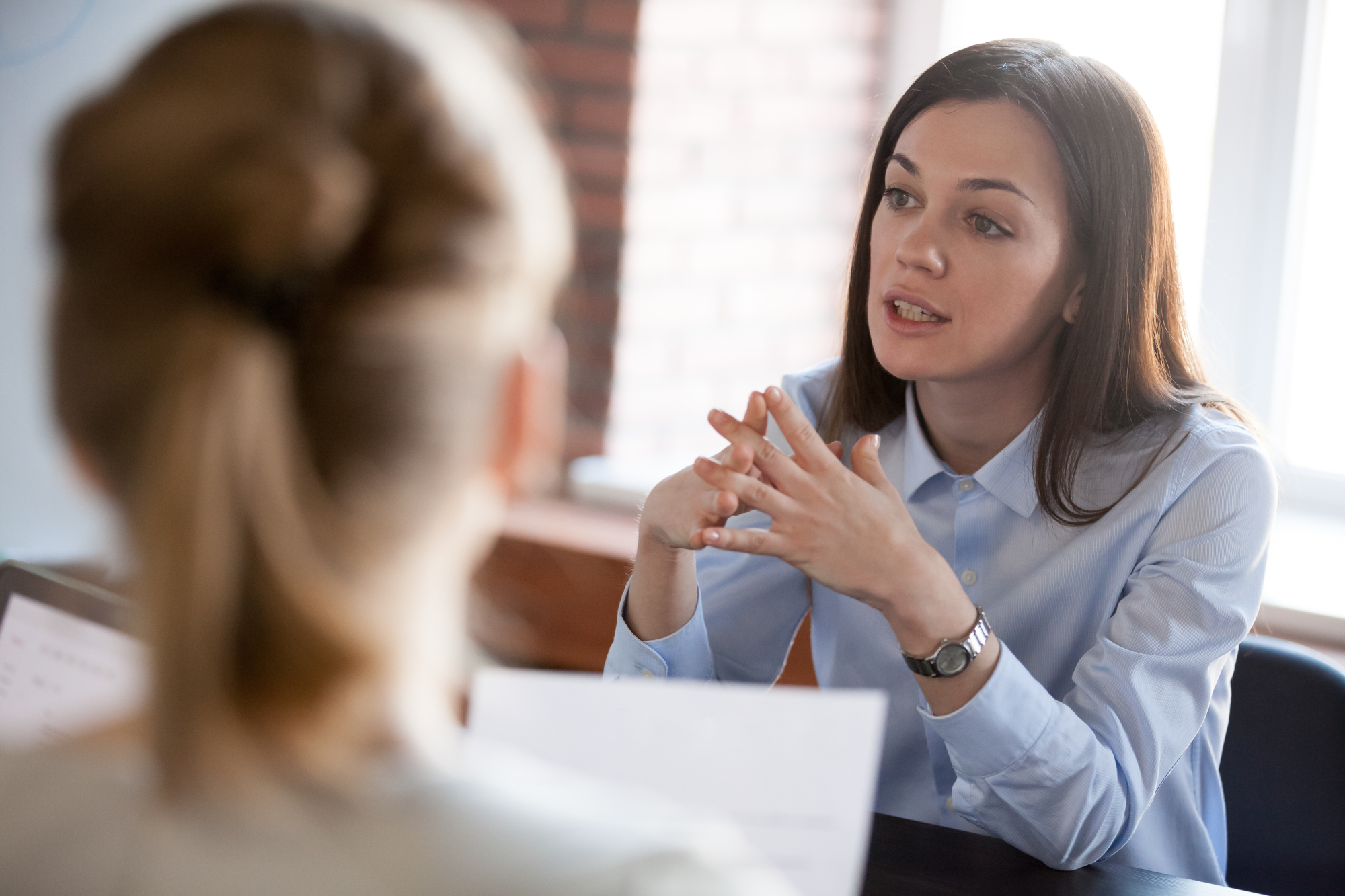 une femme d'affaire discutant avec une autre à un bureau