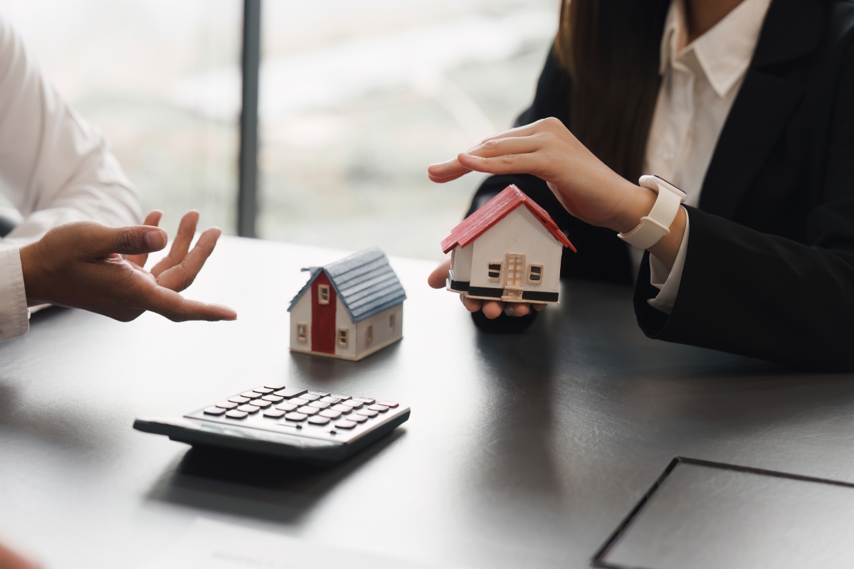 Il faut respecter certains critères pour bénéficier d’un logement locatif intermédiaire logement locatif intermédiaire – des mains d’homme durant une négociation autour de petites maquettes de maisons