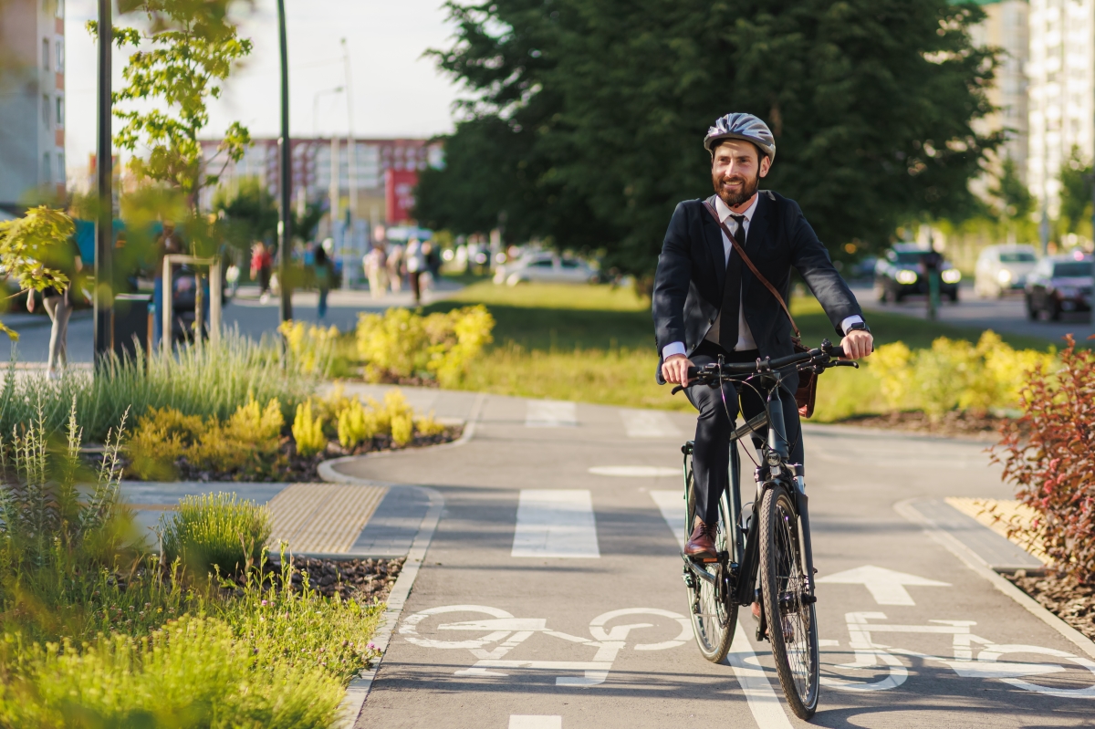 un cycliste souriant en costume sur une piste cyclable