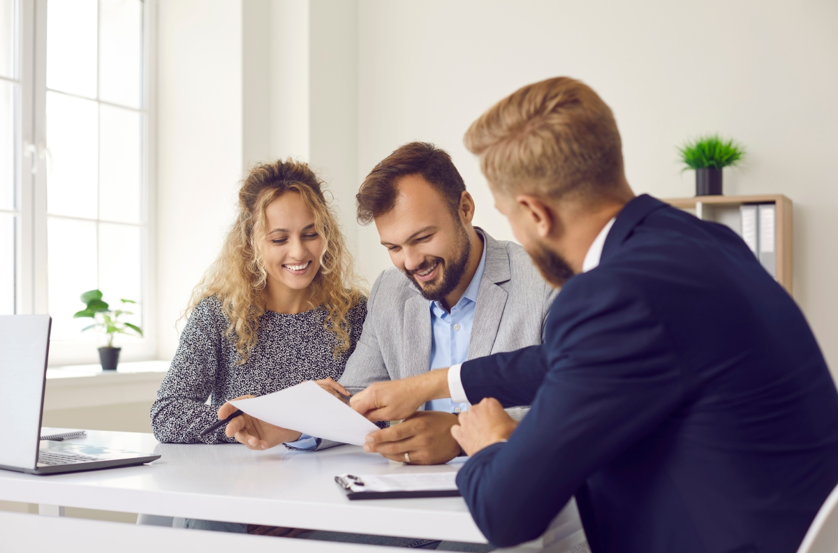 Un crédit immobilier facilité ferait du bien à de nombreux futurs propriétaires ppl crédit immobilier interêts d'emprunt pris en charge par l'employeur – un couple souriant avec un banquier