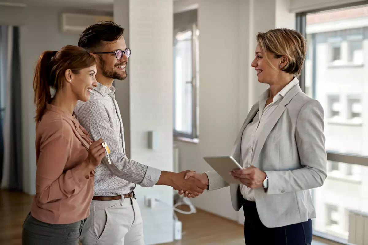 le statut du bailleur privé change la donne pour l'investissement locatif. une propriétaire bailleresse avec un couple de locataires