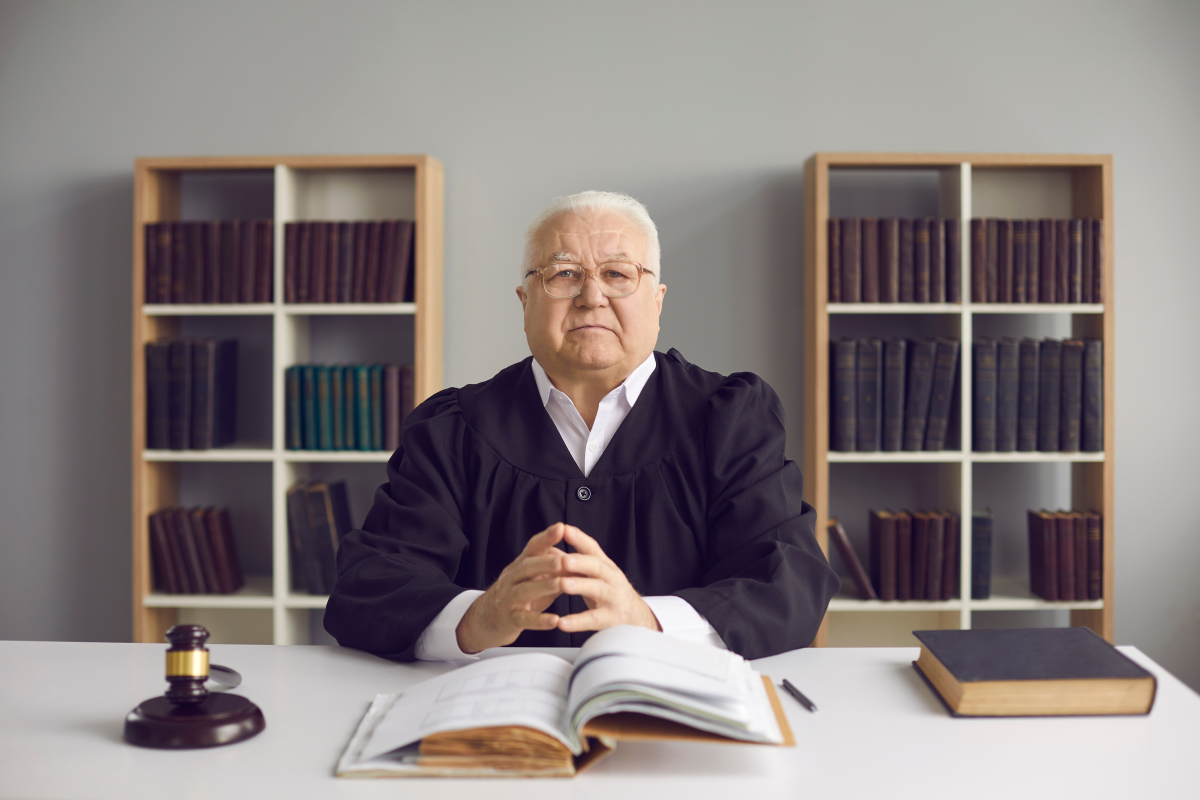 n’hésitez pas à vous faire accompagner par un professionnel en cas de doute. une professeur en droit assis derrière un bureaux face caméra