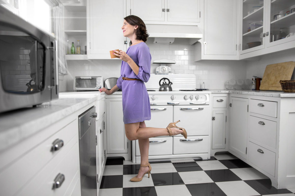 une femme boit un café dans une cuisine design