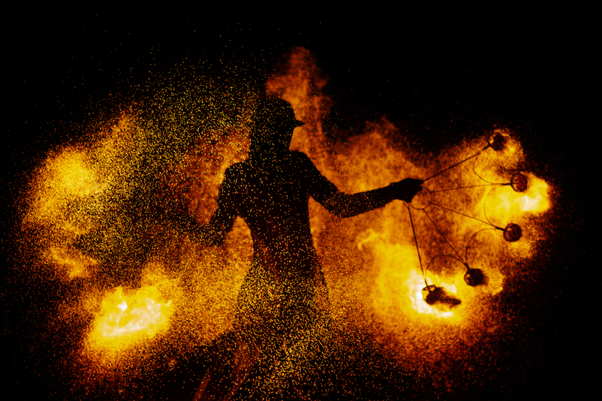 une jongleuse avec des bolas en feu