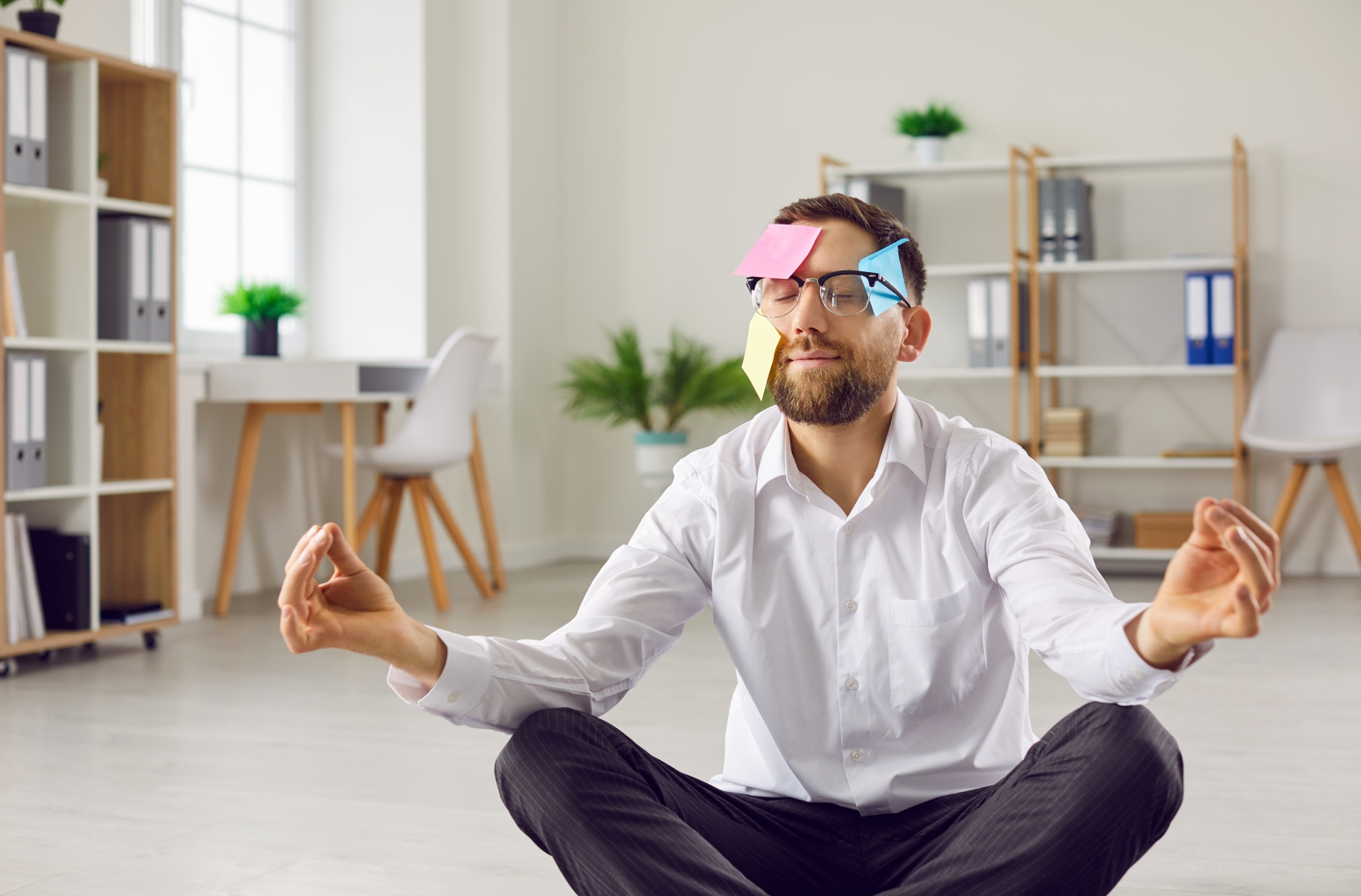 homme en pleine séance de yoga avec des post-it collés sur la visage
