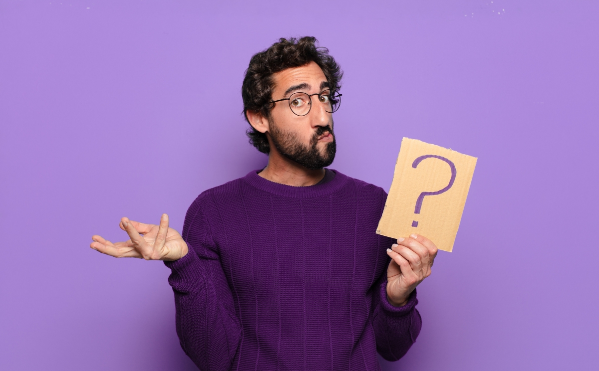 l’assurance emprunteur couvre principalement les situations extrêmes mais pas les simples défauts de remboursement. un homme se questionne sur un fond violet avec un point d’interrogation à la main