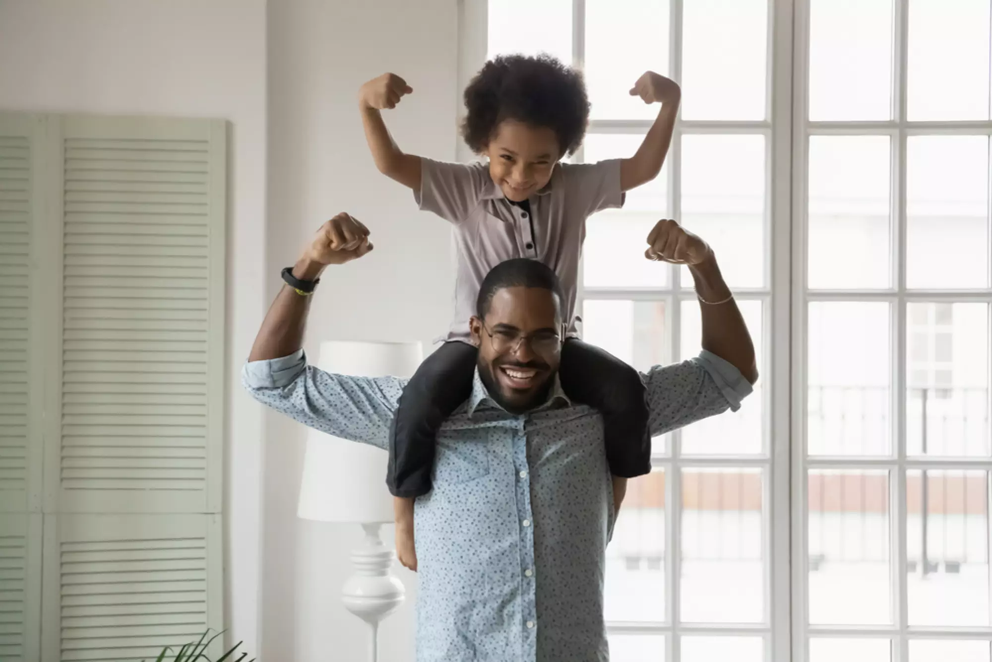 un homme et son fils sur les épaules montrent les muscles